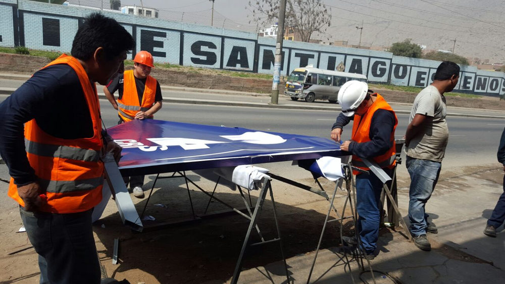Equipo de Stampa instalando una lona en la calle